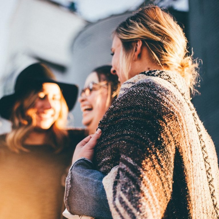Drei Frauen die lachend zusammen stehen